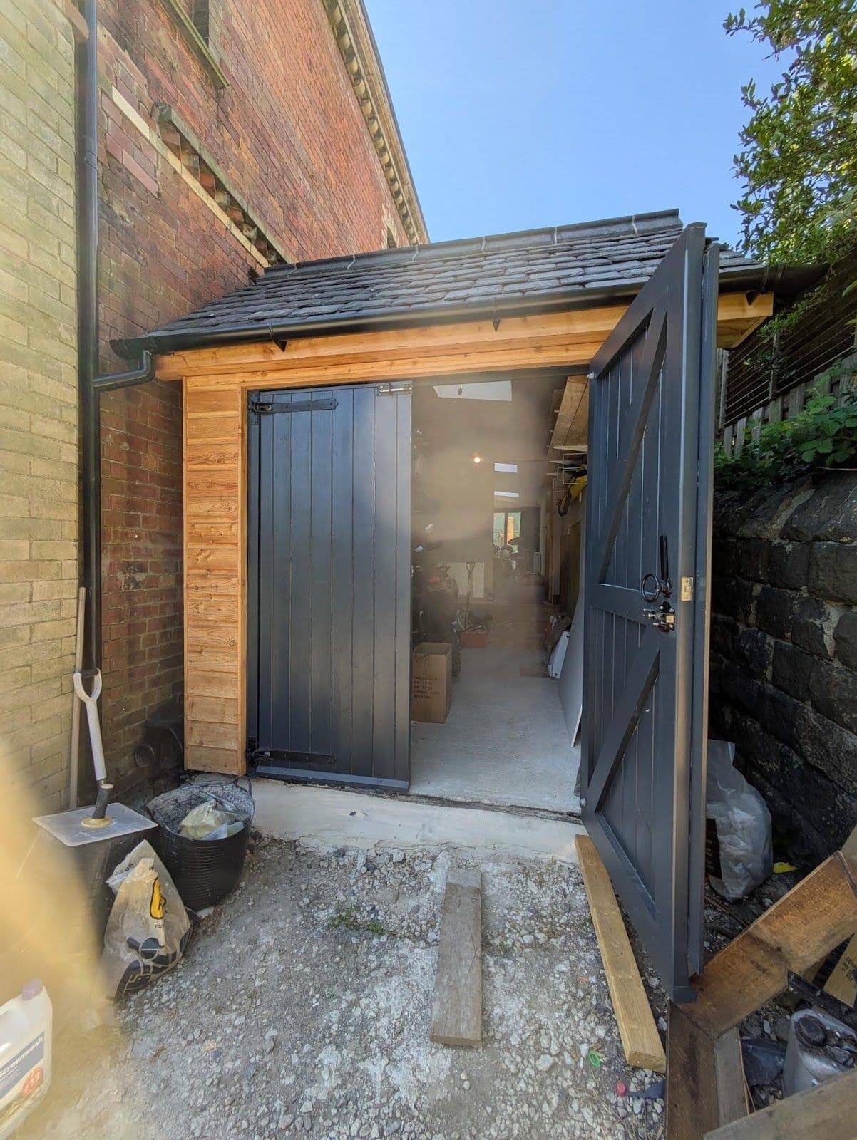 Project main view - mix used garage/outbuilding with wooden double door.